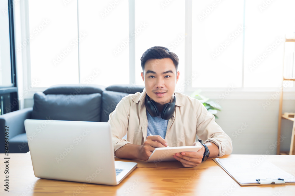 Fototapete Working from home web designing graphical user interface UX UI, home office using headphone listening music, computer laptop and pen sketching on tablet device designing creative plan innovative idea