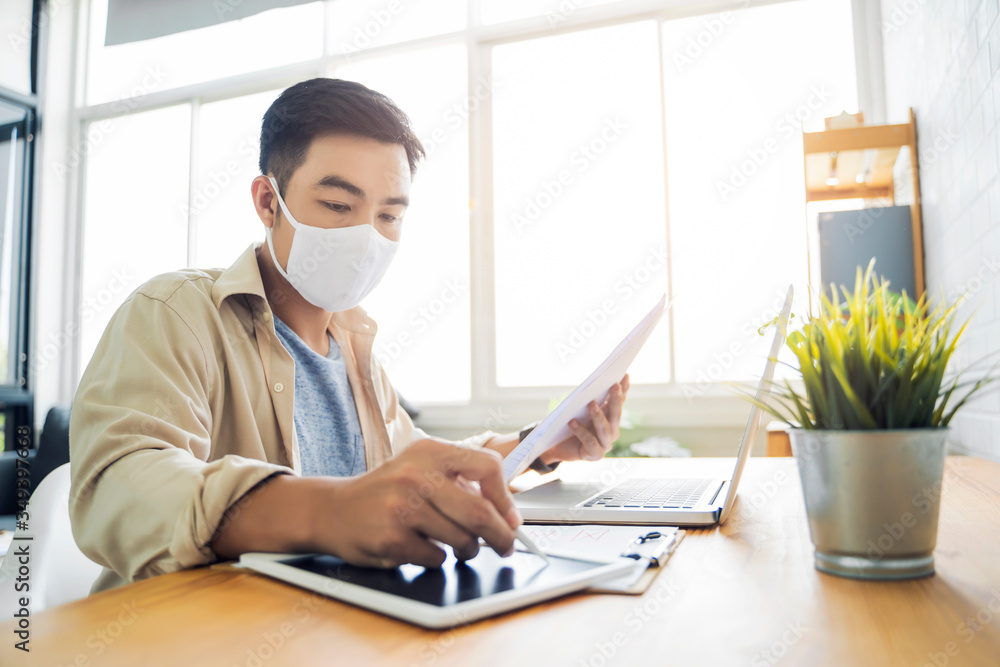 Fototapete Working from home web designing graphical user interface UX UI, using computer laptop and tablet device designing creative planning innovative idea, protective facemask quarantine coronavirus covid-19