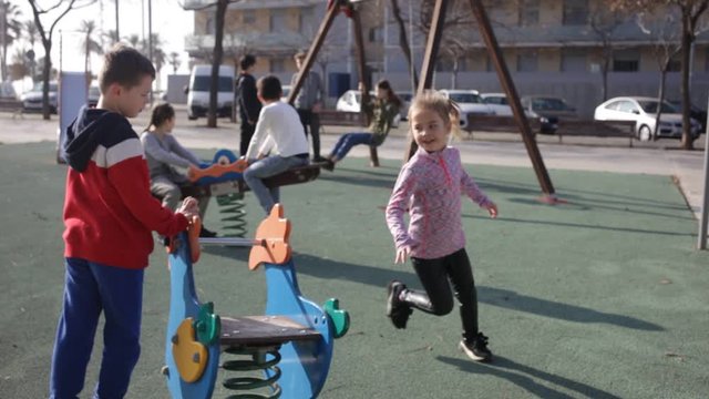 Group of children playing on jungle gym and having fun at sunny autumn day