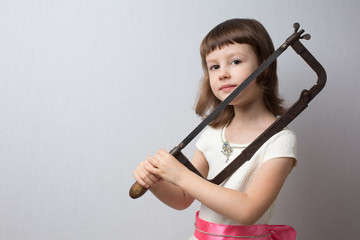 Girl holding a metal hacksaw on her shoulder