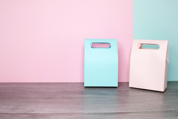 Side view on a two paper gift bags pink and blue. Pink and mint background on a back.  