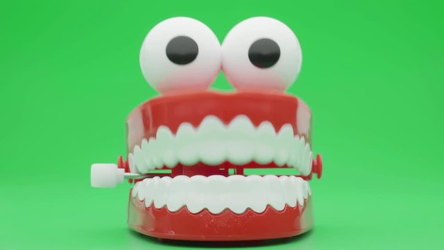 Сhattering teeth toy moving on green background.