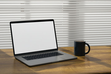 Laptop computer on a wooden surface with a coffee cup