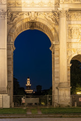 Fototapeta na wymiar Sforza Castle night view through Arco della Pace, Arch of Peace in Piazza Sempione. One of the symbols of Milan and one of the most important neoclassical monuments in the city.