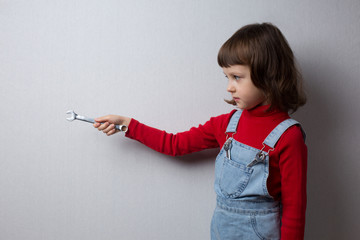 Girl holding a wrench in her hand, profile portrait
