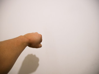 
Man's fist pointing the wall