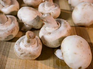 White and organic mushrooms on wooden table