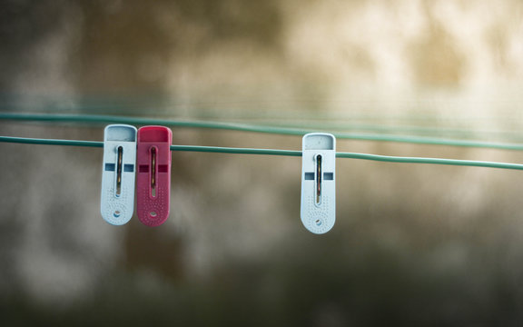 Friendzone concept. Close up a pair of clothes pegs represent a love couple  and the other cloth peg represent a people who is in friendzone.