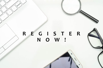 Template for registration/ membership and business from top view. "REGISTER NOW" font writing with glasses, magnifying glass, smartphone and laptop keyboard over the white background.