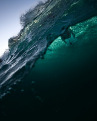 Underwater view of a surfer swimming through a large wave at Tamarama Beach, Sydney
