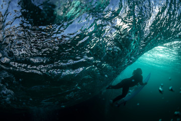 Underwater view of a surfer swimming through a large wave at Tamarama Beach, Sydney