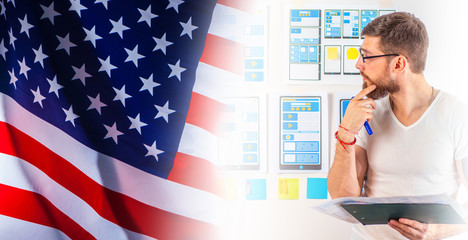A man is developing a mobile app. Mobile app designer on the background of the American flag. A man is developing a website for an American company. Remote work.