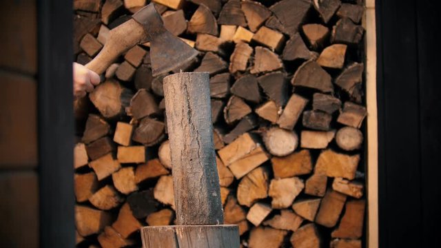 Chopping wood with an ax in woodpile