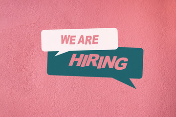 We are hiring, Text in speech bubbles on pink concrete cement wall background.