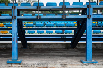 Fototapeta na wymiar empty blue plastic seats in a stadium summer mid day
