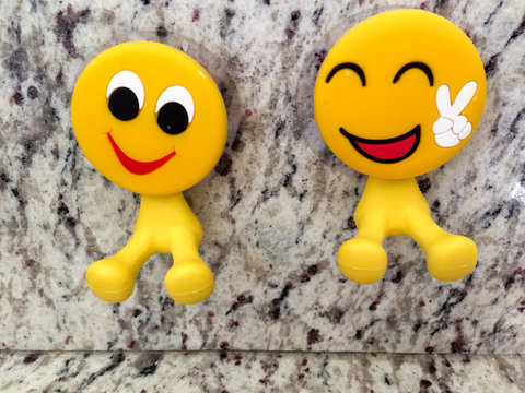 Happy fun yellow smiling emoji couple with peace sign dental toys