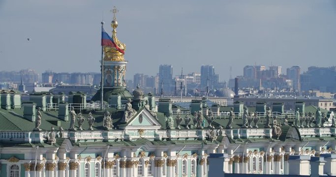 Saint-Petersburg city view from the roof. View of the Hermitage, the Winter Palace, statues and figures on the roof of the Winter Palace. Russian flag on the building of the Hermitage.