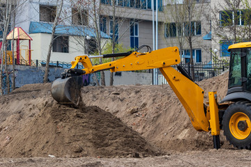 Excavator loader during earthworks at a construction site. The excavator is on the construction of a new park area.