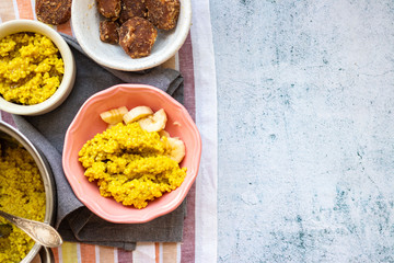 Yellow cooked millet grain cereal porridge for breakfast