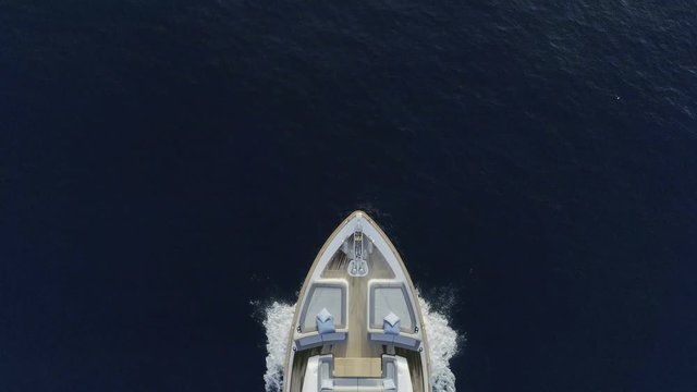 AERIAL DRONE CLOSE STILL TOP-DOWN ZENITHAL VIEW OF LUXURY YACHT SAILING IN BLUE DEEP SEA AND WHITE FOAM