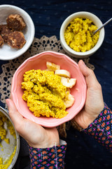 Yellow cooked millet grain cereal porridge for breakfast. Woman hands