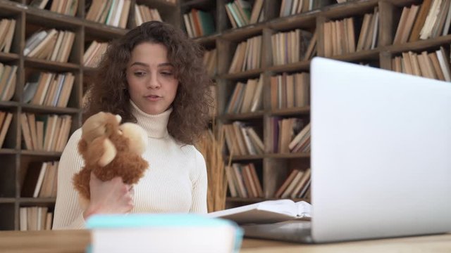 Young hispanic female remote teacher talking with toy reading fairy tale book teaching children in webcam zoom online app looking at laptop computer. Distance children video call education web class.
