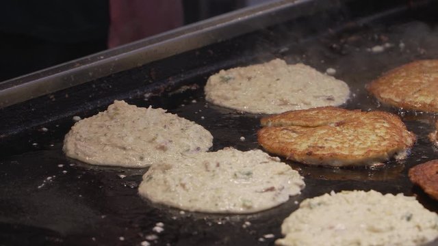 Bindae-tteok in Gukje International Market Busan city. Bindaetteok, fried buchimgae, savory pancake with ground mung beans, vegetables, meat. Korean vendors selling food in street, South Korea
