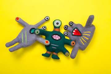 Fantastic creature soft toy made of natural wool on a yellow background