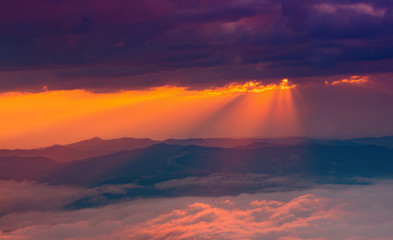 sunbeams through the clouds at sunset on the snowy mountain
