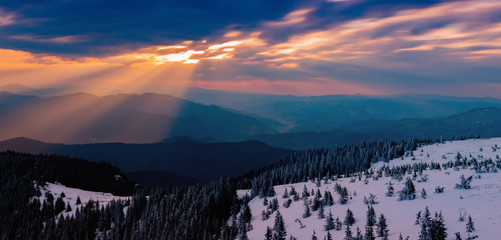 sunbeams through the clouds at sunrise on the snowy mountain