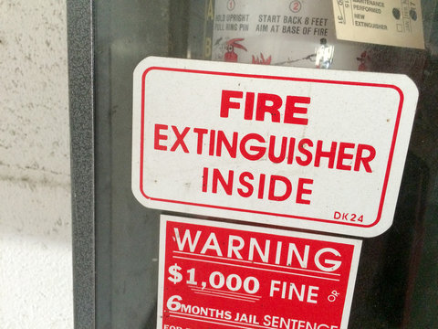 Fire Extinguisher In Glass Case On White Wall