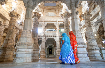 Udaipur, Rajasthan, India - February 23 2020: Indian wearing sari in Jain Ranakpur Temple marble...