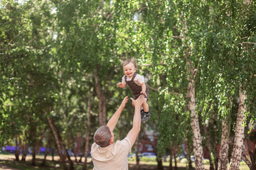 Fototapeta premium dad throws up a one-year-old son