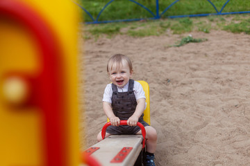 Fototapeta na wymiar a 1 year old boy rides a swing on the Playground