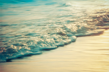 Small incoming wave surging onto the shore