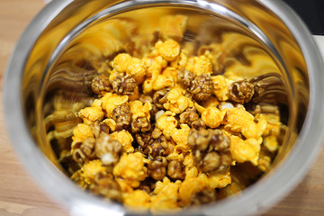 Cheddar cheese and caramel popcorn in a stainless steel bowl
