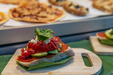 Avocado on toast served on a wooden platter with basil garnish