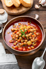 Appetizing chickpea soup served with lemon and bread.