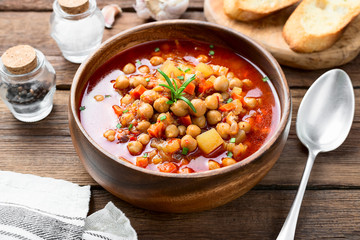 Appetizing chickpea soup served with lemon and bread.