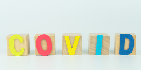 Wooden blocks with alphabet of COVID.text message on white background