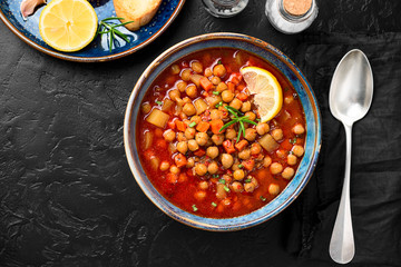 Appetizing chickpea soup served with lemon and bread.