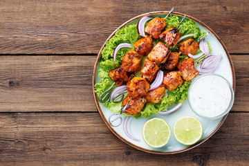 Kebabs - grilled chicken meat skewers, shish kebab with green salad leaves.
