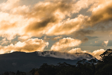 golden sunset clouds with light shining through shot over the mountains