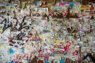 graffiti on the wall of ads with old ragged male information leaflets in the city on the wall of the house