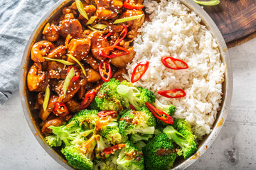 Chinese style meal with chicken stew, steamed rice and broccoli, chilli and seesame