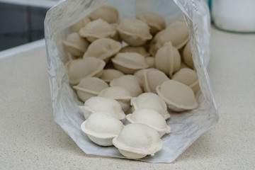 Fototapeta na wymiar homemade dumplings in a package on the kitchen table