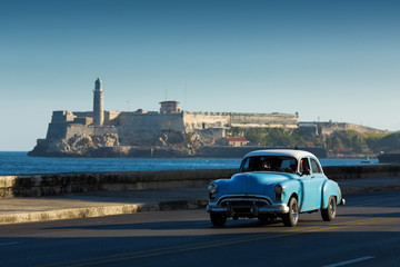HAVANA - FEBRUARY 26: Classic car and antique buildings on February 26, 2015 in Havana. These vintage cars are an iconic sight of the island