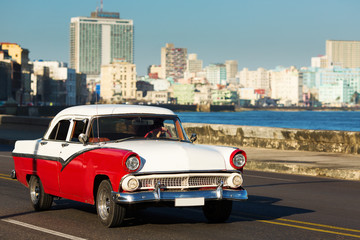 HAVANA - FEBRUARY 26: Classic car and antique buildings on February 26, 2015 in Havana. These vintage cars are an iconic sight of the island