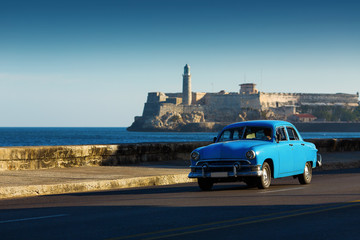 HAVANA - FEBRUARY 26: Classic car and antique buildings on February 26, 2015 in Havana. These vintage cars are an iconic sight of the island