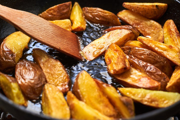 Fried crispy potatoes in oil in a pan. Cooking potatoes in a rustic way.
